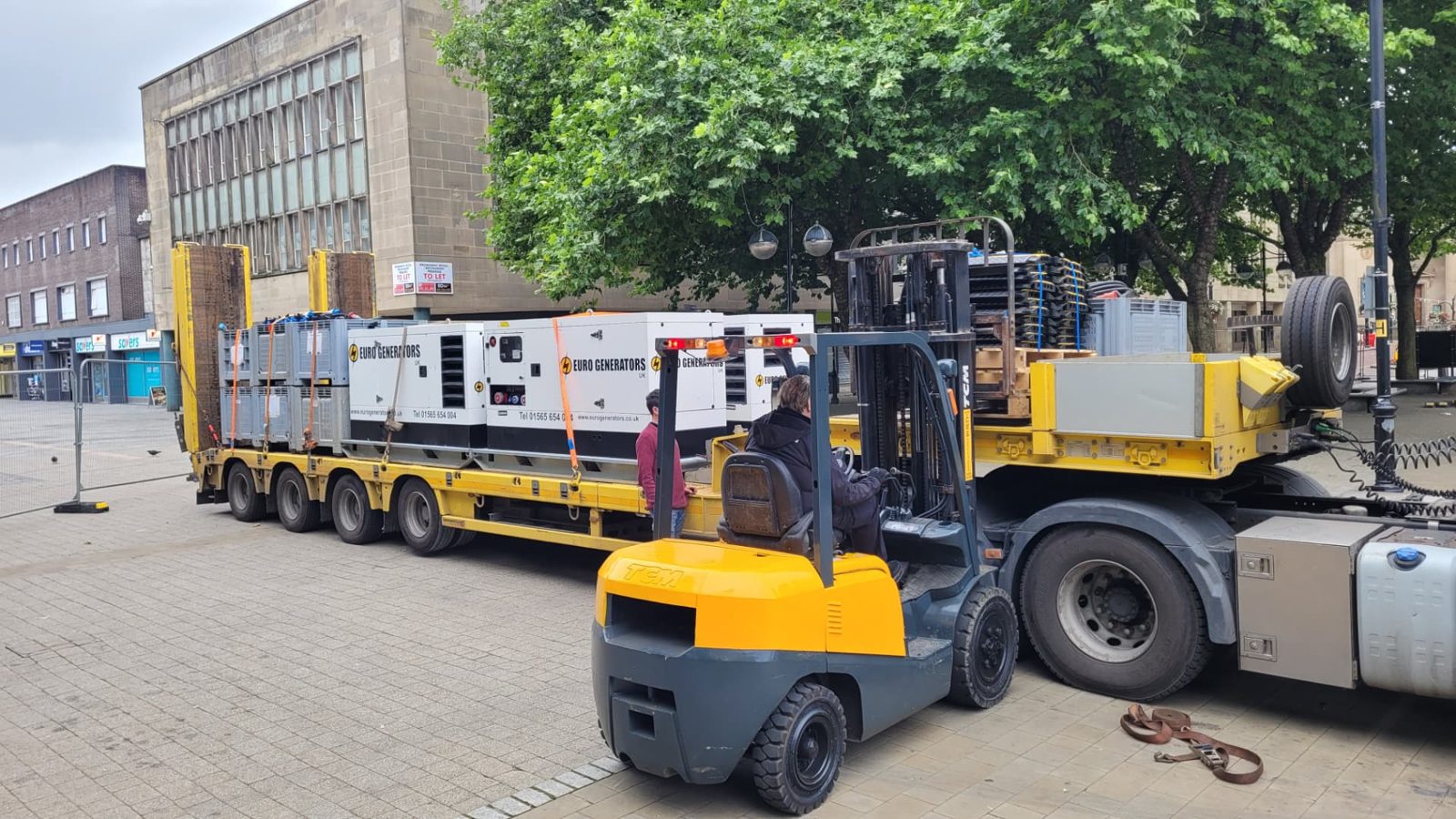 Generators being loaded onto a flatbed by forklift