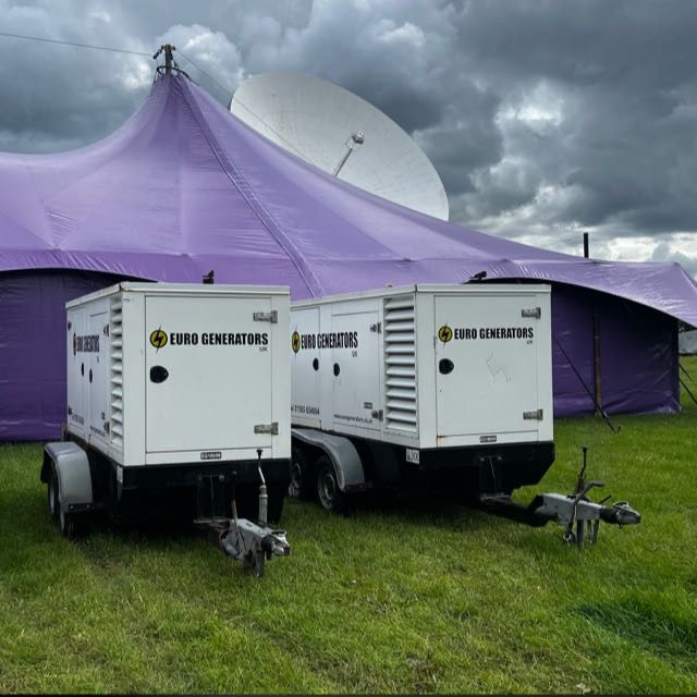 Two Euro Generators trailer sets beside a festival marquee and satellite dish