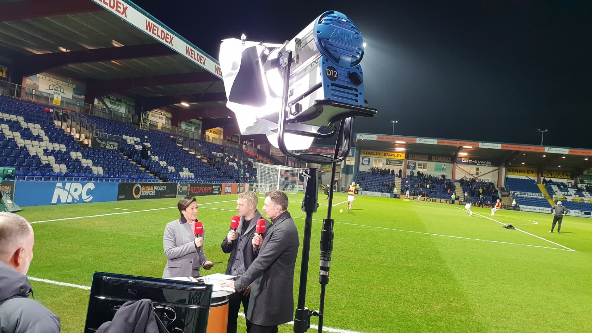 Floodlit pitch-side presentation at an evening match